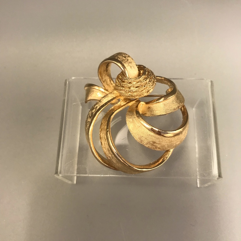 Large Vintage Ribbon metal Brooch by Cora. Stylish gold color metal